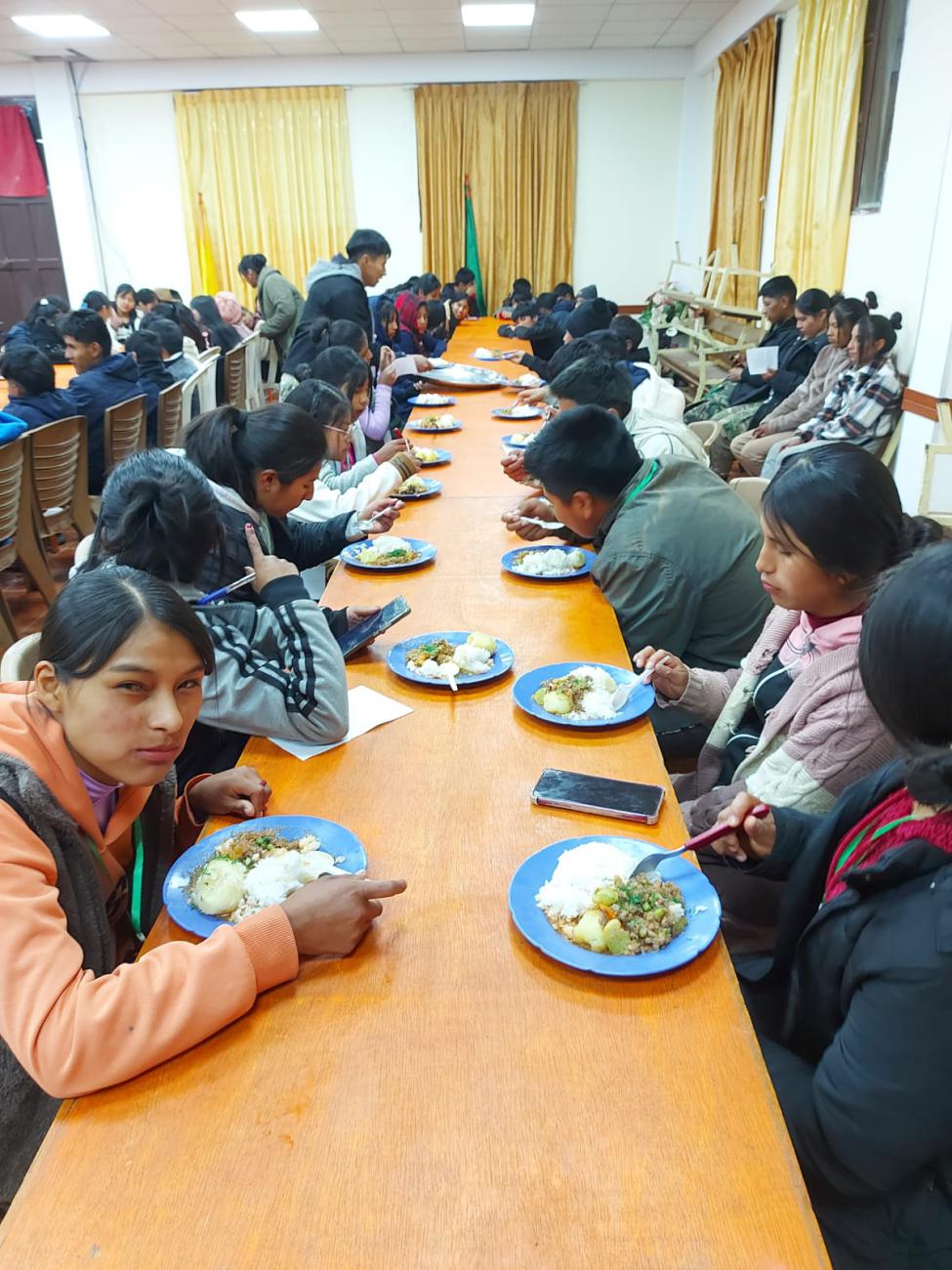 Los participantes degustando de la cena preparada por las hermanas de la cocina.