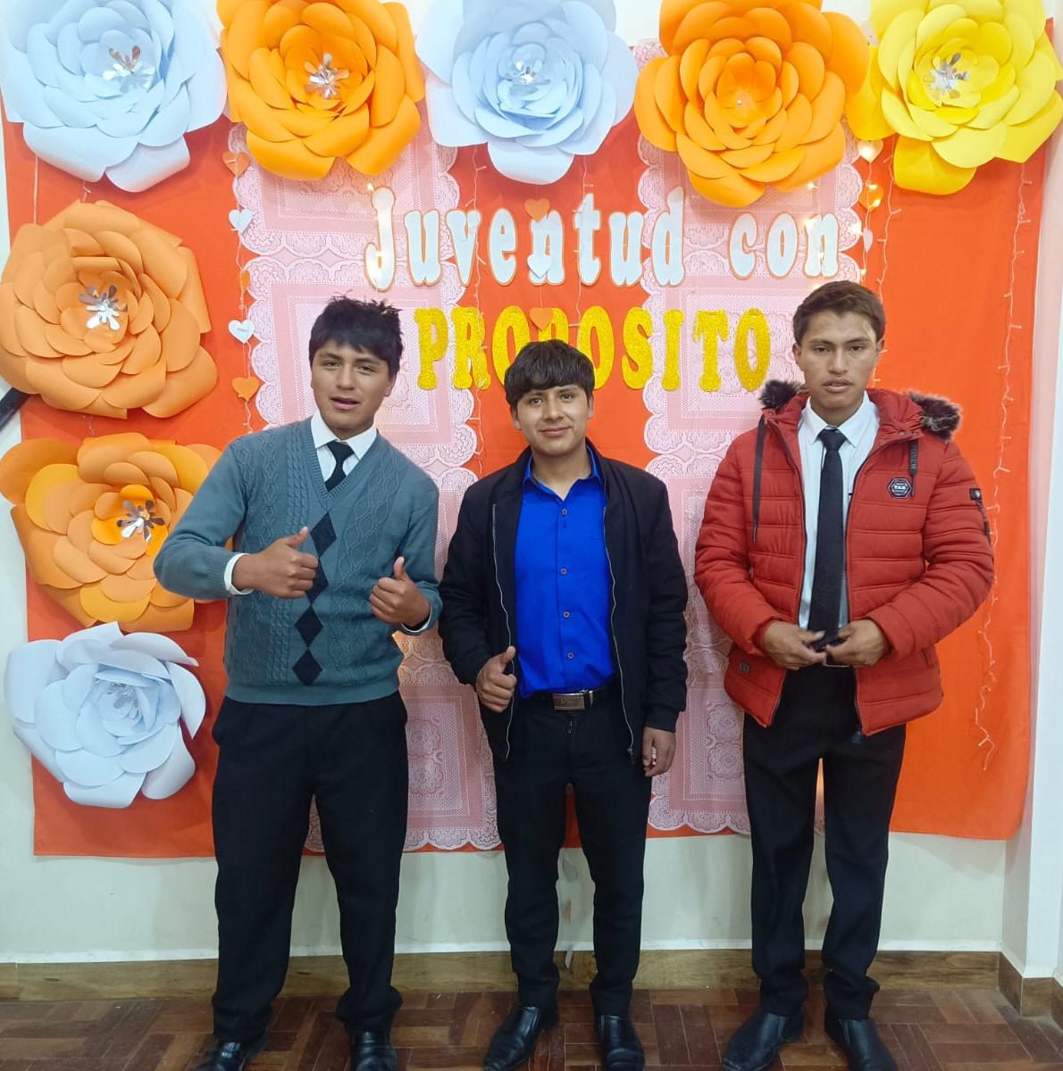 3 jóvenes tomándose una foto con el cuadro hecho por su tutora.
